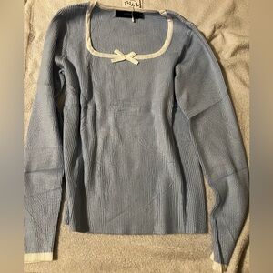 Light blue sweater with white trim and bow